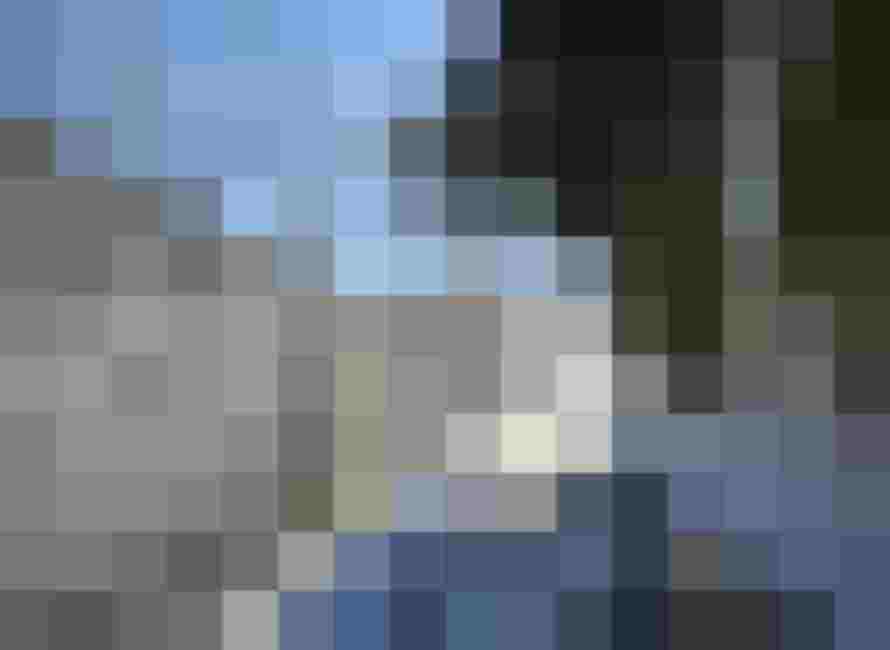 verschneiter Weg zwischen winterlichen Bäumen unter klarem Himmel