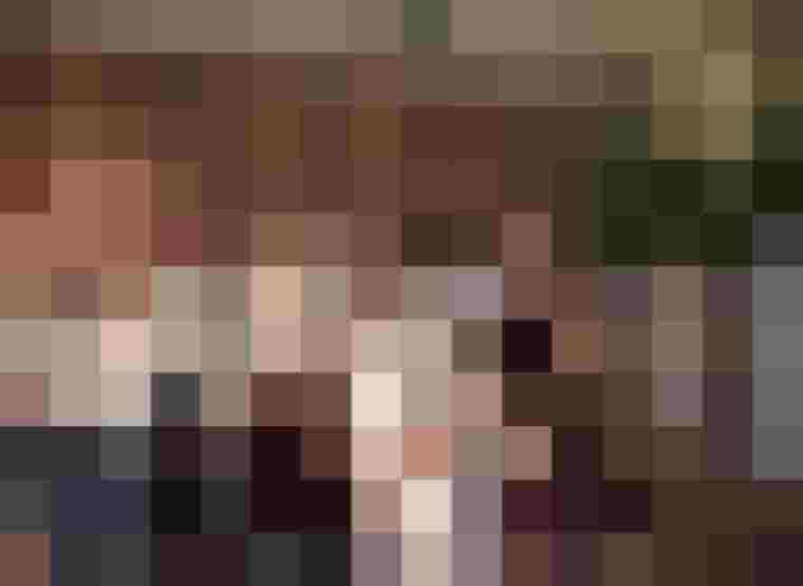 Gruppe von Erwachsenen und Kindern posiert gemeinsam in einem warm beleuchteten Innenraum