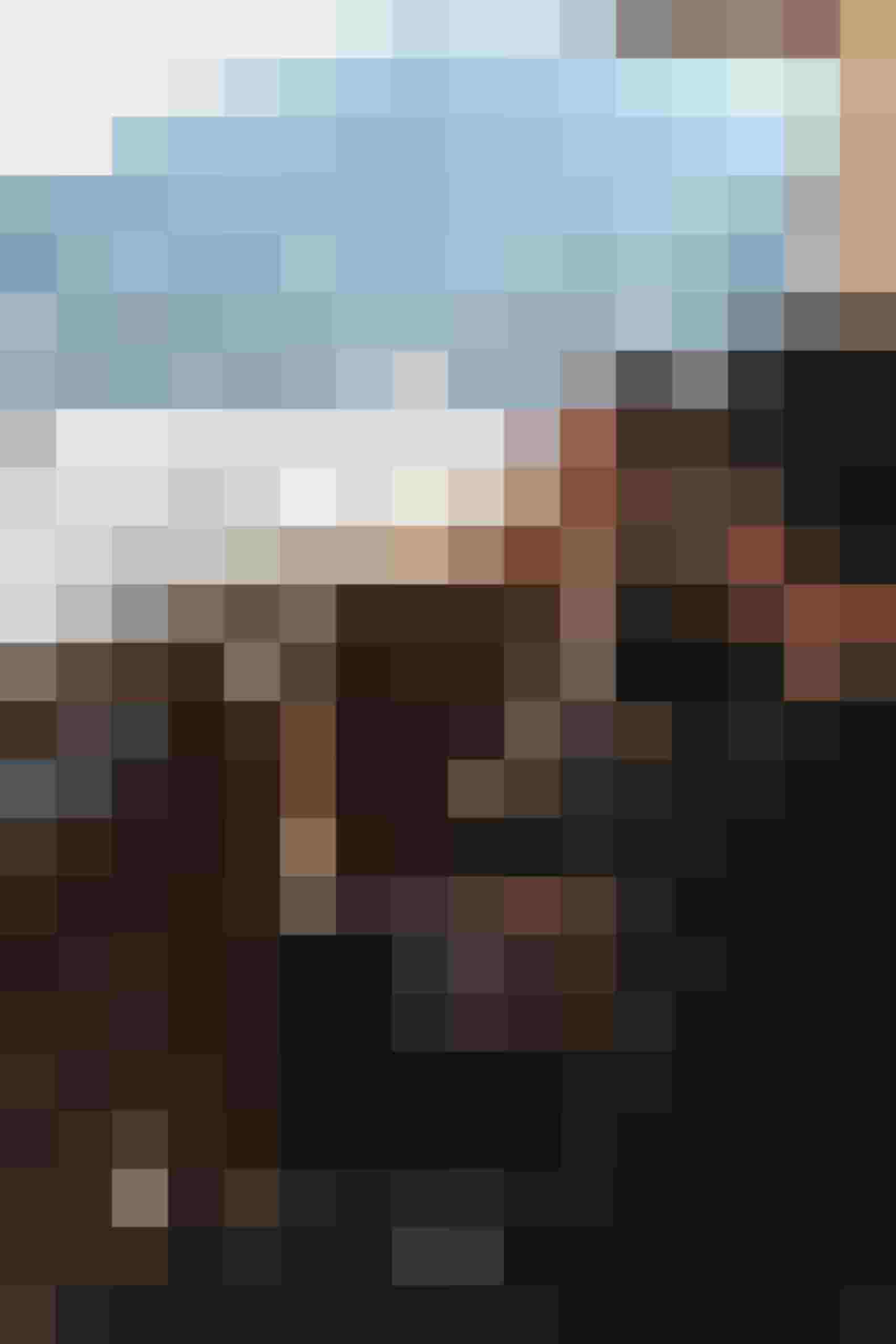 Paar auf Balkon des Appartements mit Wein und verschneitem Bergpanorama in Flachau