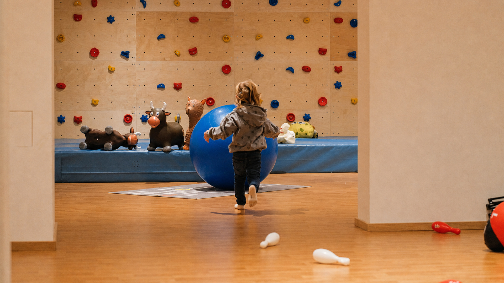 Kind spielt im Indoor-Spielraum mit Kletterwand und Turnball im Hinterrohrgut in Flachau
